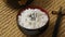 Sprinkling black roasted sesame seeds on a bowl with traditional Japanese rice