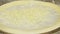 Sprinkling fresh grated cheese on pizza dough, close up. Chef is cooking pizza. Process of preparing traditional italian