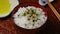 Sprinkling Wasabi furikake on top of Japanese white rice close up