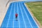 Sprinter runner athlete man sprinting on outdoor track and field running lanes at stadium. Sport and health active training on