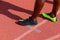 Sprinters feet wearing runners shoes standing on an athletics track