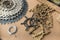 A sprocket cassette, chain, cog lock ring, spider and other components of a mountain bike drivetrain lying on a piece of cardboard