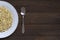 Sprouted buckwheat on half of white plate and spoon with copy space