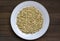 Sprouted buckwheat on white plate in center of wooden table