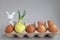 Sprouted onion in a lattice with brown eggs.a rabbit`s face is painted on the bulb.Easter decor