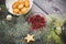 Spruce branches decorated with ginger biscuits, white meringue peaks and bright red cranberries, sesame biscuits in a white bowl