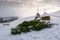 Spruce trees and haystacks on snowy hillside