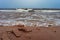 Spume waves coming to the sandy shore