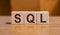 SQL text Structured Query Language on wooden cubes on orange background