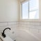 Square Alcove bathtub with white subway tiles surround with black grout