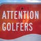 Square Attention Golfers sign at a golf course with blurry mountain and sky background