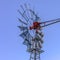 Square Back view of a steel windpump isolated against a pale blue sky background