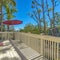 Square Balcony overlooking houses and trees against bright blue sky on a sunny day