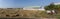 Square bales of rice hay across the field with modern barn in the back