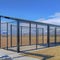 Square Baseball field dugout with slanted roof and chain link fence on a sunny day