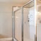 Square Bathroom interior with corner bathtub and shower stall with glass and aluminum frame