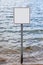 Square blank sign against waves