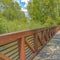 Square Bridge with rusty metal guardrails over a lake viewed on a sunny day