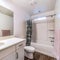 Square Built in bathtub toilet mirror and oval sink inside a residential bathroom