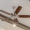 Square Ceiling fan with lights between decorative wood beams inside living room of home
