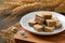 Square chocolate wafer biscuits in white dish with flower barley background