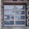 Square Close up of glass panel garage door of home with stonw brick exterior wall
