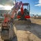 Square Close up of a red excavator with an attched grader blade viewed on a sunny day