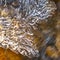 Square Close up of translucent frozen water on a rocky stream during winter