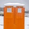 Square Close up view of a bright orange portable restroom in Daybreak Utah