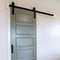 Square Closed sliding gray panel door with black handle against white wall of home