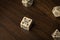 Square cream colored gaming dice on wood