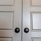 Square crop Bedroom interior with shiny double wooden door and matte black round knobs