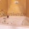 Square crop Built in white jacuzzi tub inside a bathroom with flower designs on the wall