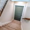 Square crop Carpeted U shaped staircase that leads down to the basement door of a home