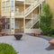 Square crop Fire pit with stone benches against building with yellow brick wall and stairs