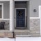 Square crop Home facade with gable roof front porch and door with wreath in winter