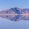 Square crop Mountains reflected as mirror image in still water