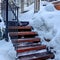 Square crop Outdoor stairway with string lights on handrails against snowy slope in winter