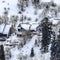 Square crop Park City mountain slope with houses amid fresh snow and evergreens in winter