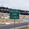 Square crop Passing Lane sign at the grassy side of road against snowy hill and cloudy sky