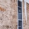 Square crop Sharp spiked icicles against windows and stone exterior wall of home in winter