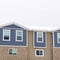 Square crop Townhome exterior with sliding glass windows brick walls and vertical sidings