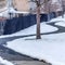 Square Curvy narrow road on snow covered ground in winter with houses background