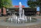 Square in dutch town with water fountain and modern municipal theater building