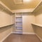 Square Empty walk-in closet with warm color lighting and shelving units