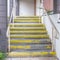 Square Exterior steps with yellow warning treads on a sunny day