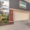 Square Exterior of three storey townhomes with garages and red gray and beige walls