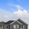 Square Exterior of the top floor of a house with blue sky and bright clouds background