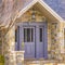 Square Facade of a home with a beautiful stone wall and gray front door