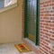 Square Facade of a home with a small porch and classic red brick wall